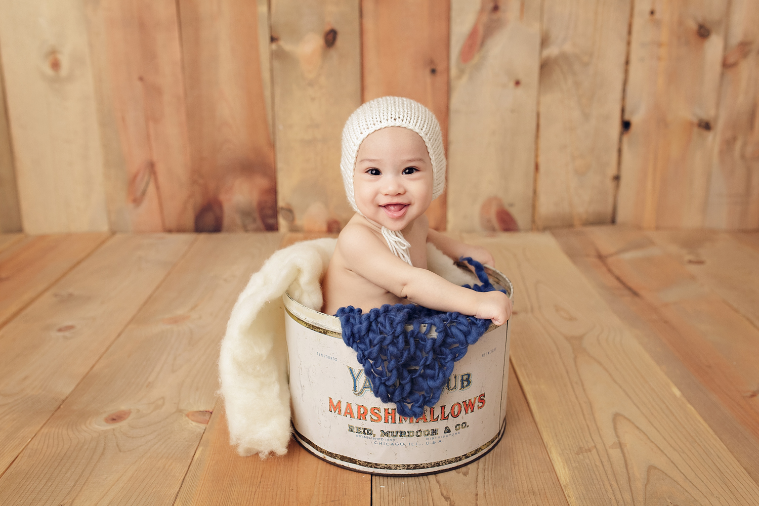 Earthy portraits of baby in a vintage marshmallow tin for his 6 month photo session.