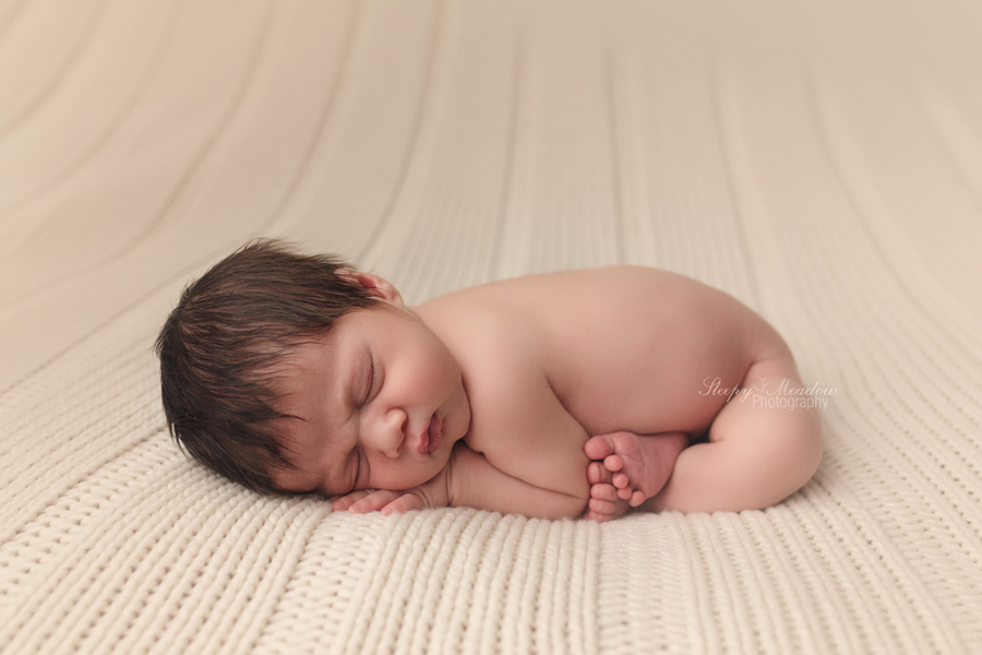 Newborn boy posed on cream blanket by Sleepy meadow Photography