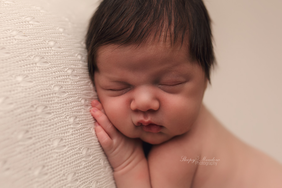 Pictures of of chubby cheeked baby boy during his newborn session with Sleepy Meadow Photography.