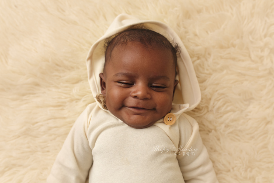 Baby boy smiles in his sleep during his three month pictures at Sleepy Meadow Photography located in Brookfield, WI.