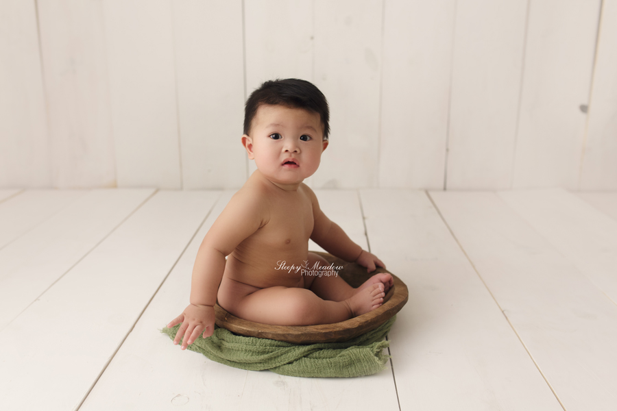 Baby poses in vintage bowl with green wrap for his 7 month photo shoot.
