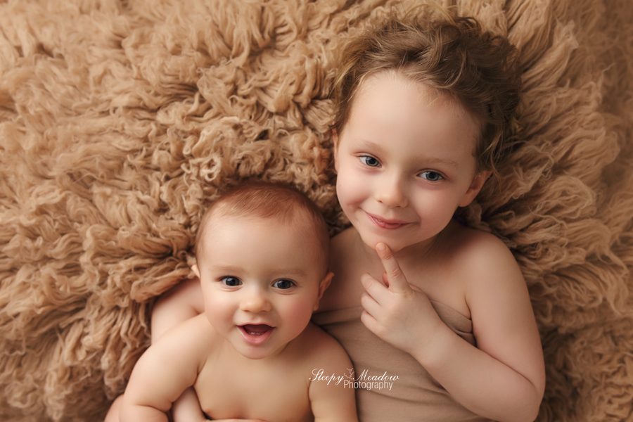 Waukesha baby boy takes a picture with his sister during his 8 month photos shoot with Sleepy meadow Photography.