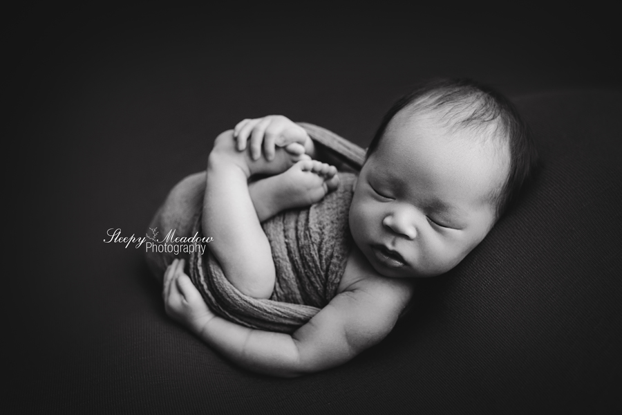Milwaukee newborn boy posed naturally as if he was in the womb by Sleepy Meadow Photography.