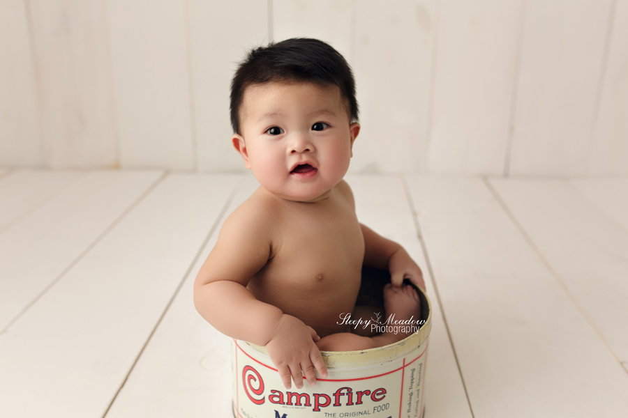 Baby boy poses in vintage campfire tin for his newborn pictures with Sleepy Meadow Photography of Kenosha.