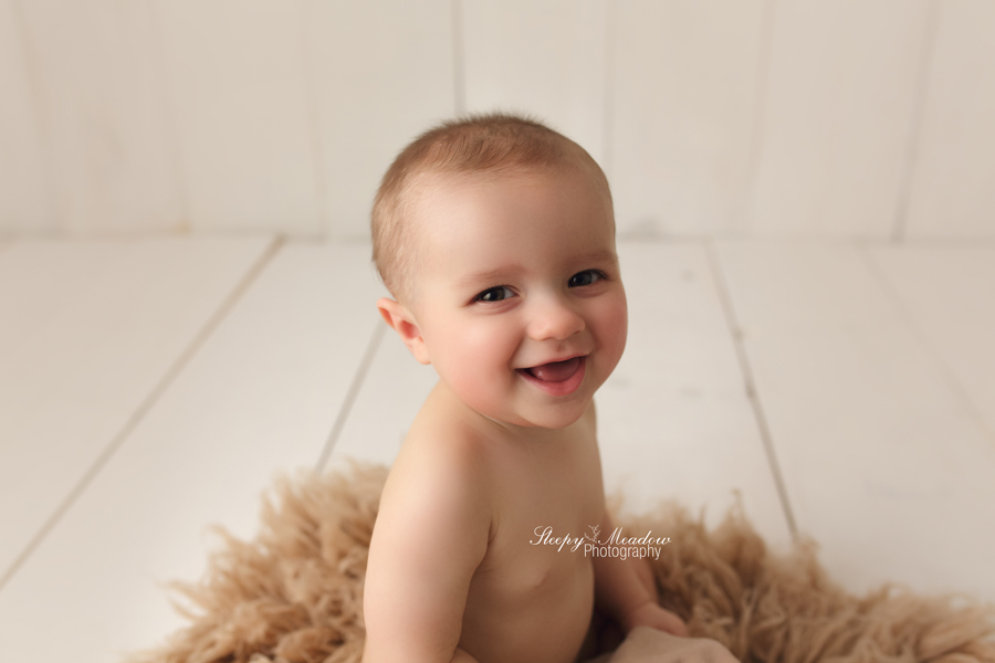 Baby boy poses on a fur rug during his photoshoot in Waukesha County at Sleepy Meadow Photography.