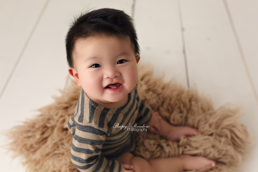 Adorable baby boy smiles for his milestone session at a Waukesha County portrait studio.