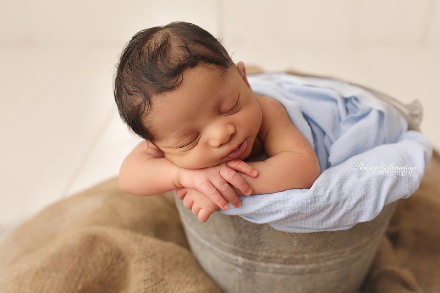 Baby poses in a bucket by Sleepy Meadow Photography | Milwaukee Newborn Photographer