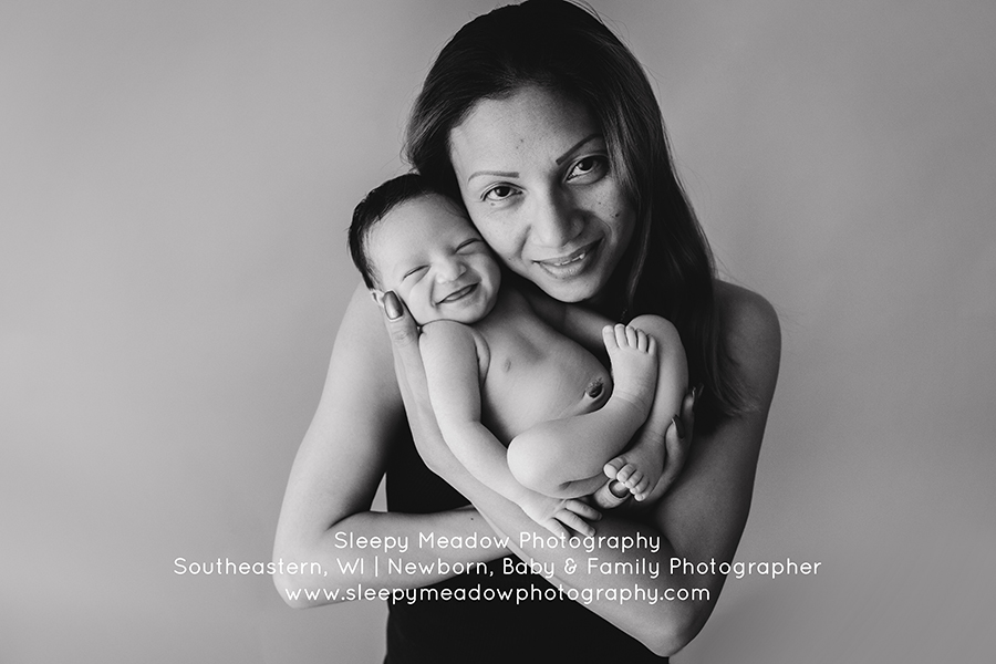 Adorable baby smiles while his mom holds him | Waukesha Newborn Photographer