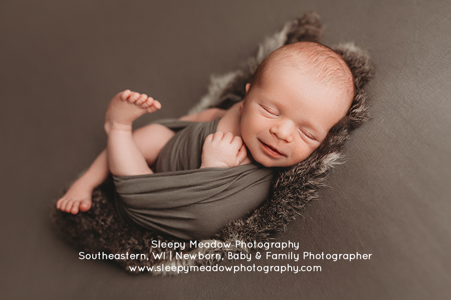 Baby smiles for his newborn session in Kenosha. | Sleepy Meadow Photography