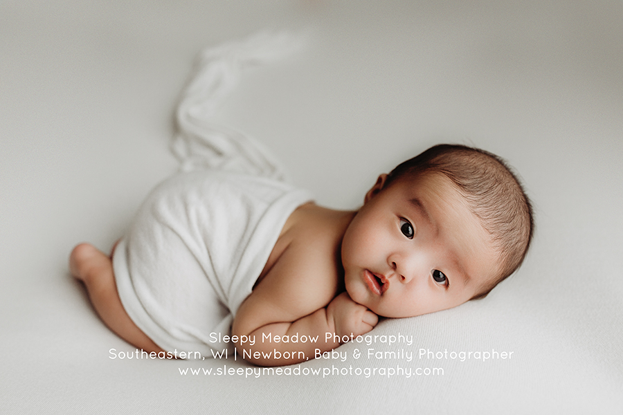 Newborn boy posing on white fabric | Milwaukee Baby Photographer