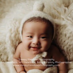 Smiling baby wearing bonnet | Sleepy Meadow Photography