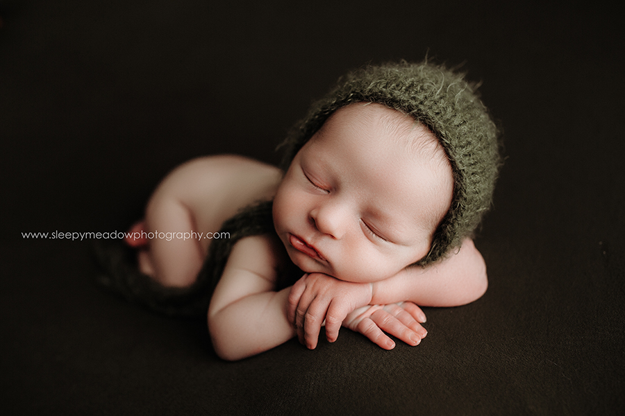 newborn boy wearing green bonnet